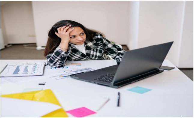 Business owner staring at a laptop with social media stats, expressing confusion and frustration over poor engagement.