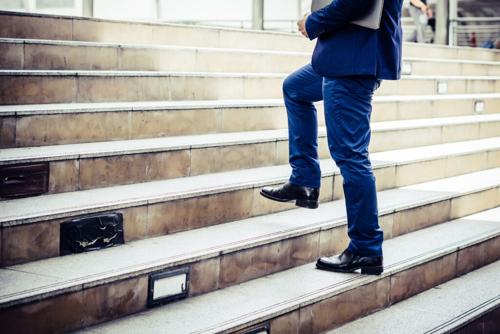 Businessman confidently stepping up toward growth.