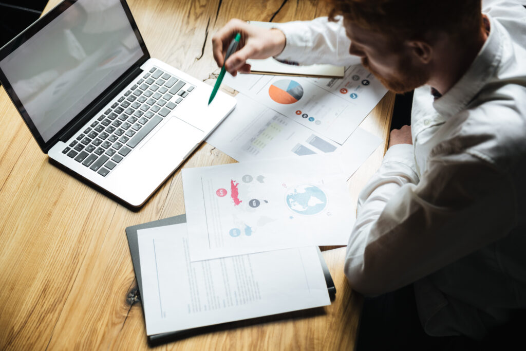 Focused professional analyzing charts at desk.