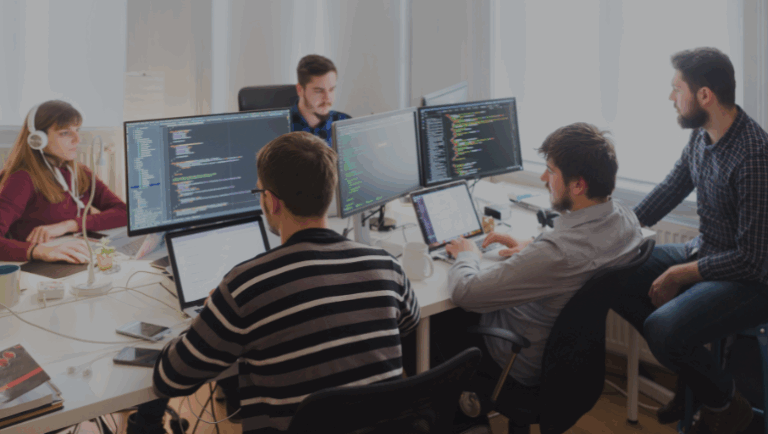 Group of talented software developers engaged with computers in an office, creating solutions for diverse business needs.