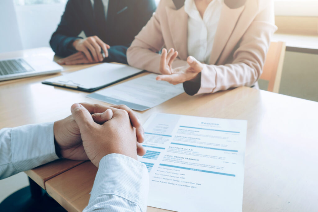Interview panel reviewing resume during job interview.