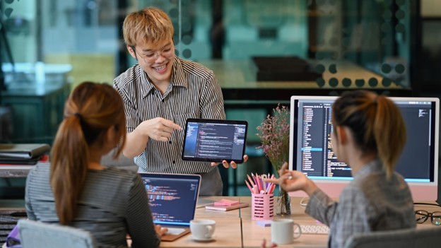 A man and woman collaborate on a computer, discussing the importance of customized websites for business success.