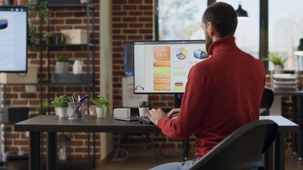 Business analyst examining data dashboard on computer.