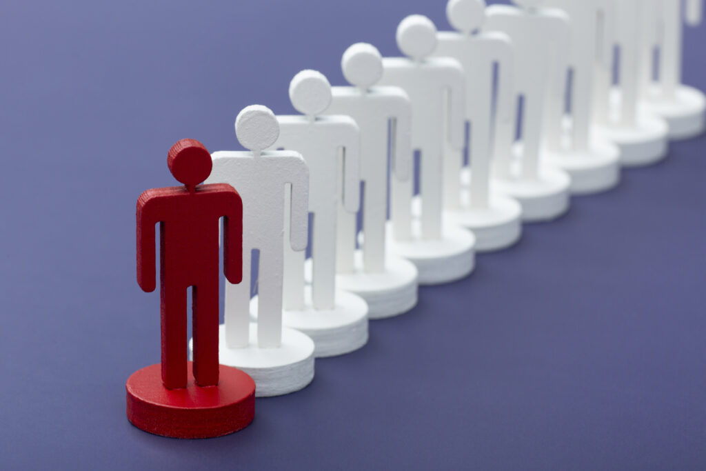 Red figure standing out in front of white human icons.